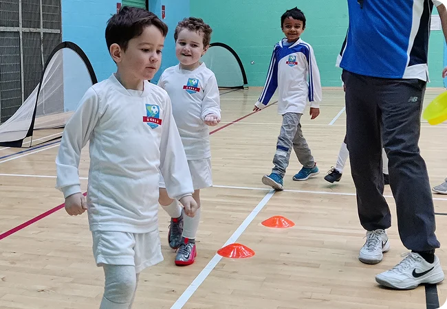 Our Educational Teaching Method A coach explaining an educational sports game to young children.